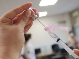 Ministério Público tenta evitar fura-fila monitorando a vacinação nos municípios close em mão feminina segurando apola de dose e agulha enfiada na ampola - mpsc fiscaliza para evitar fura-fila