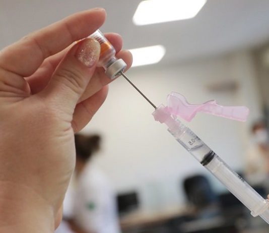 close em mão feminina segurando apola de dose e agulha enfiada na ampola - mpsc fiscaliza para evitar fura-fila