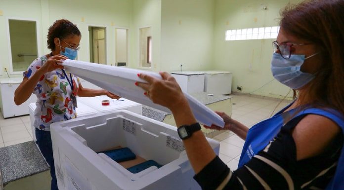 duas servidores abrem caixa de isopor para distribuição do segundo lote de vacina por região de Santa Catarina