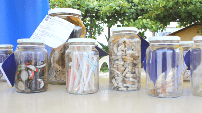 Alguns potes de vidro contendo lixo marinho