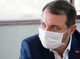 Governador Carlos Moisés no lado direito da foto, de máscara branca com olhar fixo no canto esquerdo