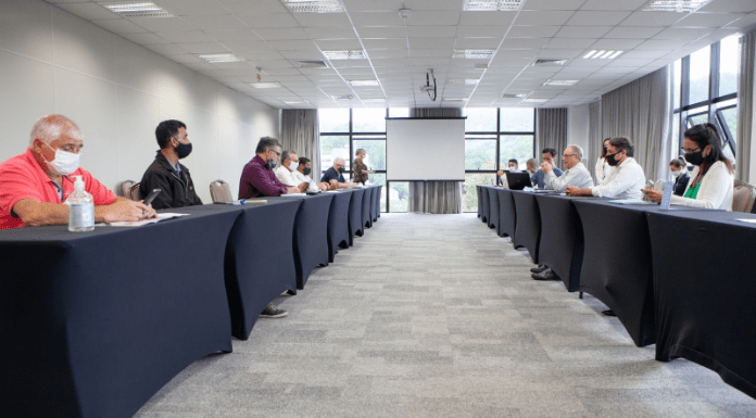 Empregadores e trabalhadores em reunião presencial na FIESC, com distanciamento social e máscaras.