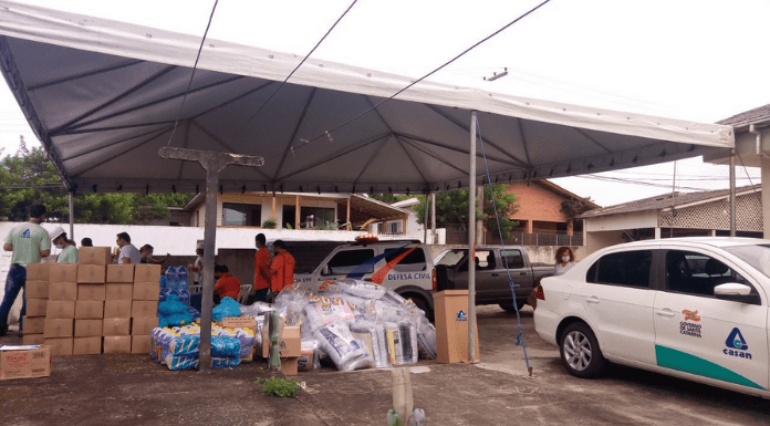 Adiantamento emergencial: Tenda na Lagoa da Conceição, com veículos e funcionários da Casan, e alimentos e materiais para os moradores da região