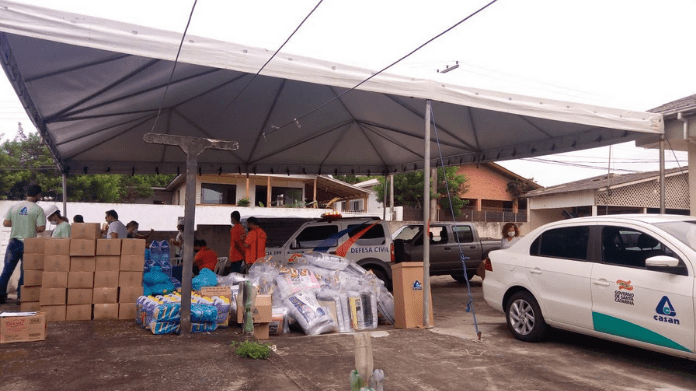 Adiantamento emergencial: Tenda na Lagoa da Conceição, com veículos e funcionários da Casan, e alimentos e materiais para os moradores da região