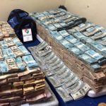 PM apreende 5 milhões de reais - foto mostra uma montanha de maços de notas de real e dólar