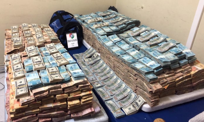 PM apreende 5 milhões de reais - foto mostra uma montanha de maços de notas de real e dólar