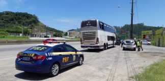 Passageiro é preso porque tentava fotografar e filmar mulher em ônibus - viatura da prf estacionada atrás do ônibus em beira de rodovia