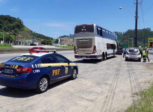 Passageiro é preso porque tentava fotografar e filmar mulher em ônibus - viatura da prf estacionada atrás do ônibus em beira de rodovia
