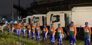 coleta de lixo com empresa privada emergencial em florianópolis - funcionários enfileirados e uniformizados em frente aos caminhões