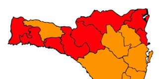 mapa de sc divido em 16 regiões com 8 no vermelho, 7 na laranja e uma no amarelo para risco ao coronavírus