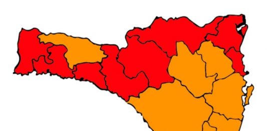 mapa de sc divido em 16 regiões com 8 no vermelho, 7 na laranja e uma no amarelo para risco ao coronavírus