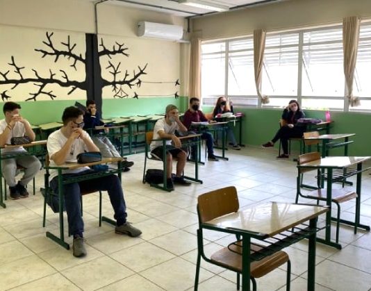 Governo de SC vai pagar R$ 6,2 mil para estudantes permanecerem na escola calendário escolar estadual - alunos sentados em carteiras separadas usando máscara dentro de sala de aula