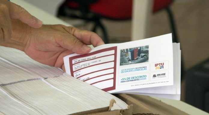 pessoa segura carnê de iptu de são josé - distribuição de carnês do IPTU nos bairros