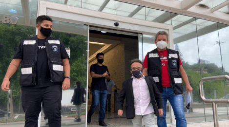 Gabrielzinho junto a outros dois homens em frente ao detran para notificar por vazamento dados