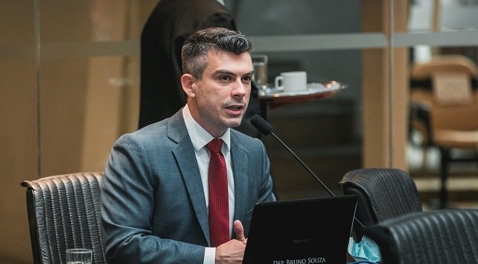 Deputado Bruno Souza usa terno e fala em microfone em bancada da alesc; ele lançou projeto de voluntários para fiscalização do poder público em SC