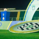 banner do figueirense em gramado com palanques da cbf ao fundo e bola em pedestal