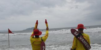 Guarda-vidas sinalizando para pessoa no mar