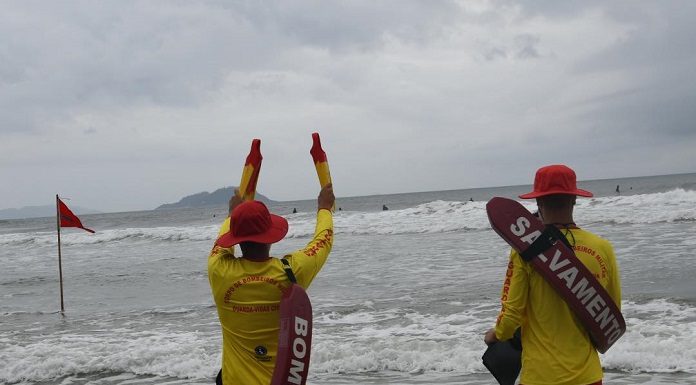 Guarda-vidas sinalizando para pessoa no mar