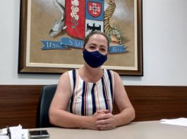 Presidente da Câmara de Vereadores de São José, Méri Hang sentada, com os braços em cima da mesa e de máscara