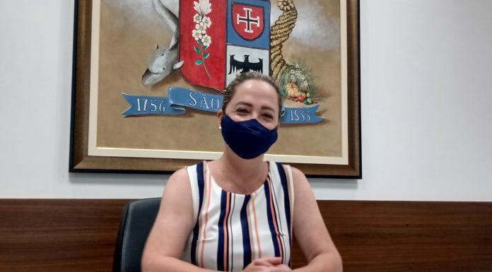 Presidente da Câmara de Vereadores de São José, Méri Hang sentada, com os braços em cima da mesa e de máscara