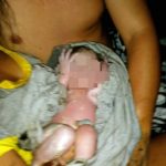 mãe dá à luz na sc 401 - a foto mostra ela com o bebê embrulhado no colo, com rosto censurado