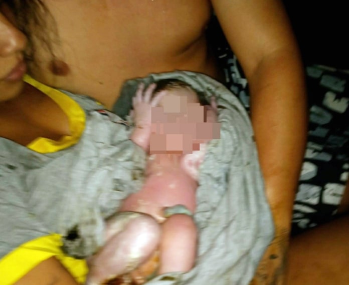 mãe dá à luz na sc 401 - a foto mostra ela com o bebê embrulhado no colo, com rosto censurado