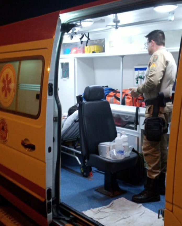 policial em pé dentro de ambulância do samu após mãe dar à luz na sc 401