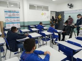 Aulas em São José retornam em 22 de fevereiro com diagnóstico dos estudantes alguns alunos usando máscaras em carteiras com outros adultos de máscara na sala - aulas em são josé retornam em 22 de fevereiro