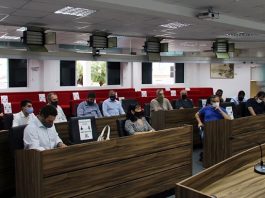 vereadores usando máscaras sentados nas bancadas com presidente falando em pé à frente em reunião que definiu que parlamentares de São José não usarão celulares
