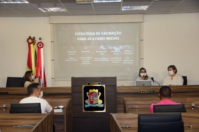 Prefeitura de São José presta esclarecimentos à câmara sobre plano de vacinação - pessoas na reunião na câmara e apresentação em tela