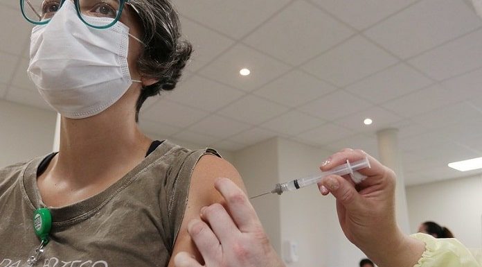 mulher recebe dose de vacina no braço - SC recebe mais doses
