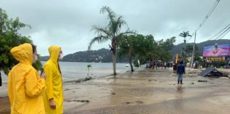 técnicos do ima usando capas de chuva olham para avenida das rendeiras tomada por lama - análise do órgão mostra que lagoa está com mais coliformes fecais