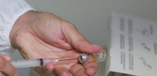 29,6 mil doses da Coronavac chegam a Santa Catarina neste sábado profissional de saúde retira dose de vacina de ampola com agulha, close nas mãos - Governo de SC mantém meta de vacinar 2,8 milhões dos prioritários em 2021
