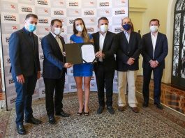 723 novos professores efetivos são empossados na Secretaria de Educação estadual 723 novos professores efetivos são empossados sc - secretário e moisés com outras pessoas segurando placa para a foto; todos de máscara; mulher de vestido azul ao centro