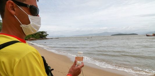 bombeiro faz coleta de água em praia para verificar índice de poluição nos pontos do litoral