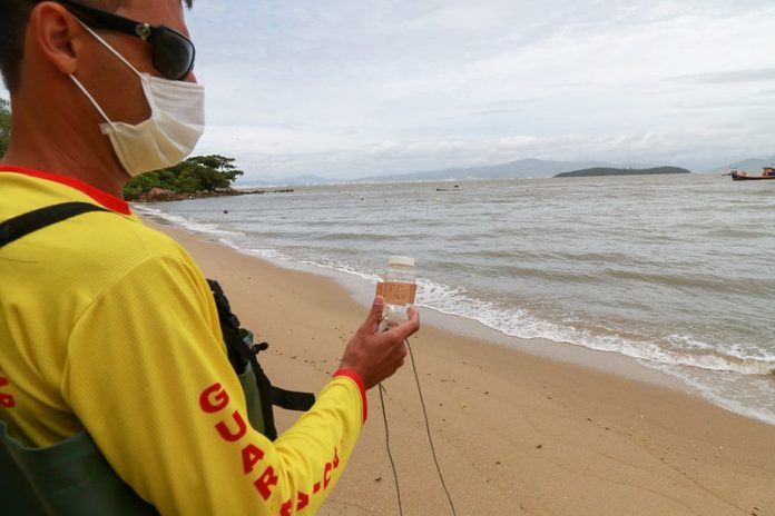 bombeiro faz coleta de água em praia para verificar índice de poluição nos pontos do litoral