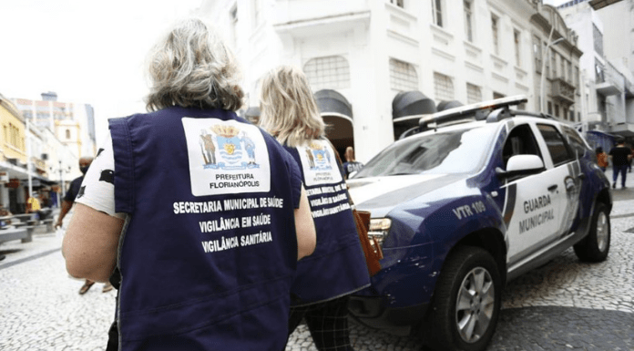 Duas mulheres de costas com o uniforme da Vigilância Sanitária da PMF