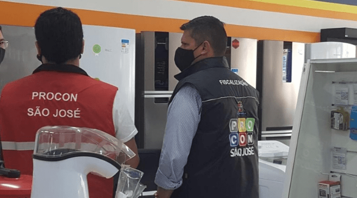 Dois agentes do Procon de São José de costas, realizando fiscalização em um estabelecimento do município