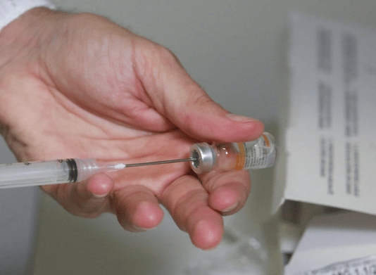 Vacinação em idosos: Sintram-SJ pede vacinação para os professores municipais: profissional da saúde colocando a vacina contra a covid-19 em uma seringa