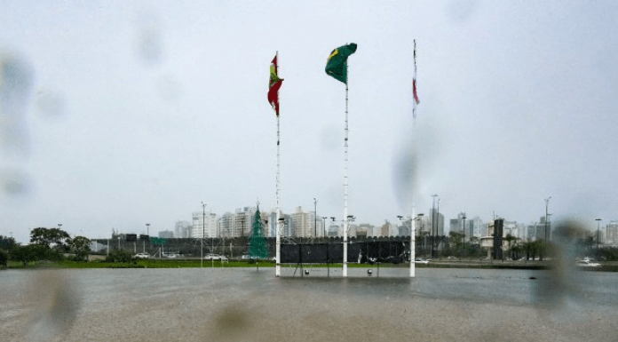 Chuva em Florianópolis e três bandeiras no centro da imagem