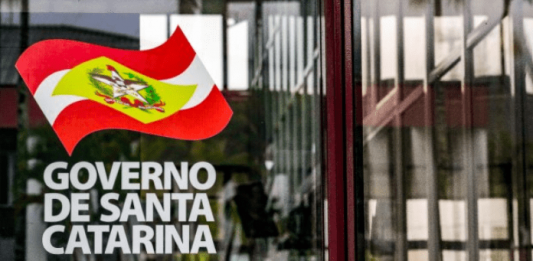Recuperação fiscal: Adesivo colado em porta de vidro, escrito Governo de Santa Catarina e a bandeira do Estado