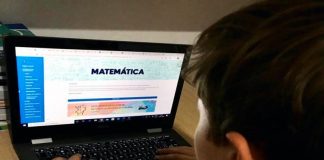 Ano letivo na rede municipal de Florianópolis começa com aulas online - garoto visto de costas no notebook com tema de matemática na tela