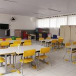 Sala de aula vazia, com mesas brancas e cadeiras amarelas. No próximo dia 22 as aulas retornam presencialmente em São José e os professores farão o teste de Covid