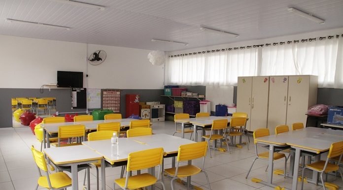 Sala de aula vazia, com mesas brancas e cadeiras amarelas. No próximo dia 22 as aulas retornam presencialmente em São José e os professores farão o teste de Covid