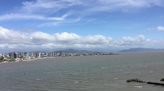 céu azul com nuvens brancas, prédios ao fundo e mar, onde deve se desenvolver o transporte marítimo da Grande Florianópolis - licitação do transporte marítimo em estudo