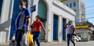 homem e duas mulheres usando máscaras caminham com sacolas pelo centro de florianópolis - comércio catarinense cresceu. apesar da pandemia