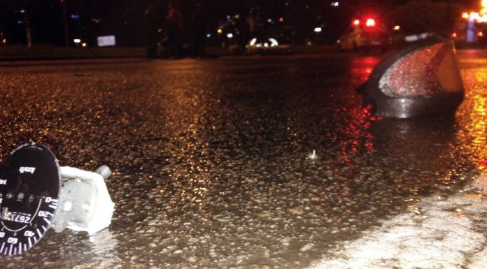 Motorista com sinais de embriaguez bate de frente em moto no Centro - a foto mostra no chão da via o velôcimetro da moto e a viseira do capacete quebrados e caídos sobre chão molhado