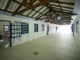 Pátio vazio de uma escola com paredes brancas e portas e janelas azuis, com estrutura de madeira no teto. O sindicato dos servidores de Palhoça decidiu não voltar presencialmente nas escolas.