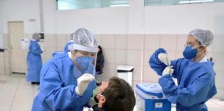 profissional de saúde com epi coloca cotonete no nariz de homem para teste de coronavíris - na região há mais de 3 mil casos ativos