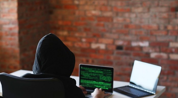 Ataques hackers em Santa Catarina visam órgãos do governo e prefeituras - para ilustrar, foto mostra pessoas de capuz, sem ter identificada, mexendo em notebooks